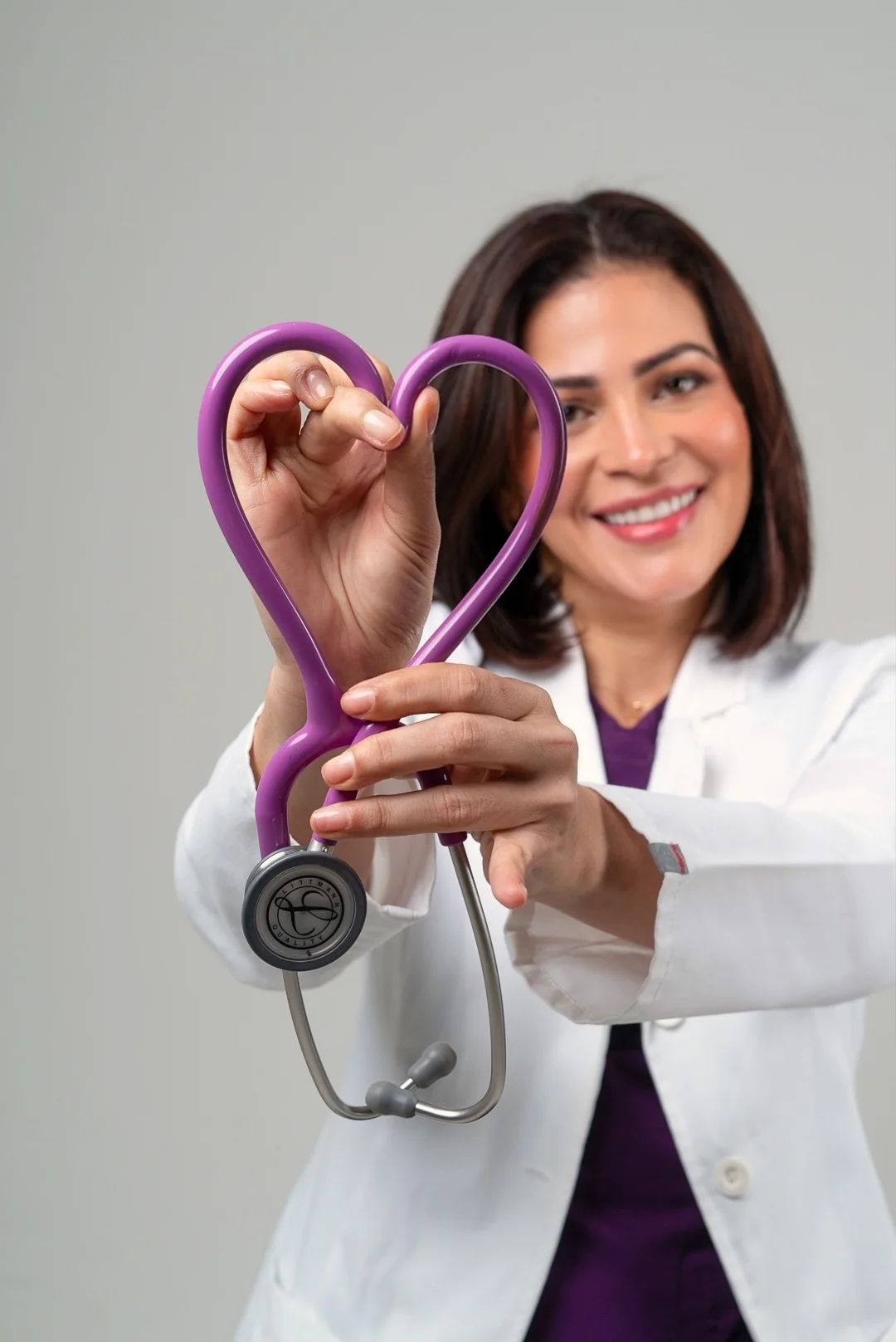 La doctora forma un corazón con su estetoscopio
